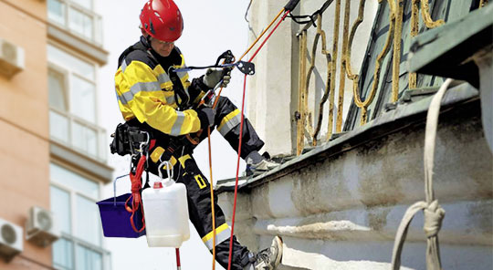 Personal laborando con equipo de protección para alturas y sistema de rescate.