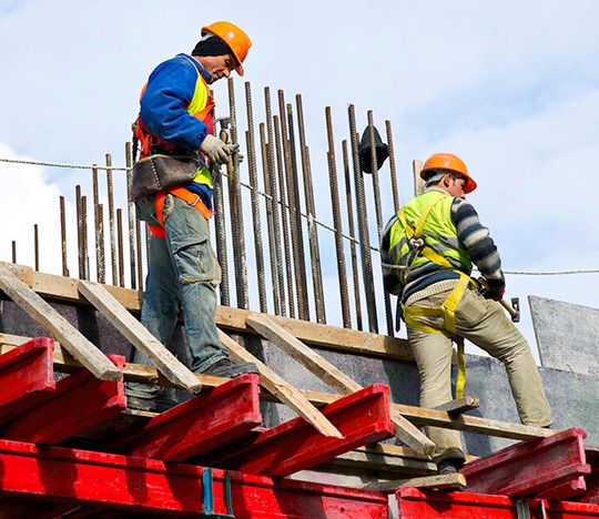 Trabajadores usando equipo de Seguridad Industrial en las alturas.